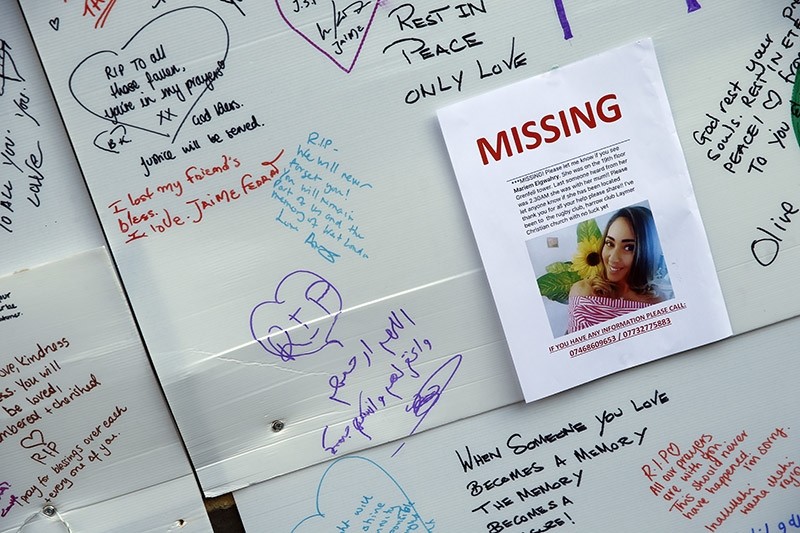 A schoolgirl looks at messages of support for victims, missing and those affected by the massive fire in Grenfell Tower, in London, Thursday, June 15, 2017. (AP Photo)