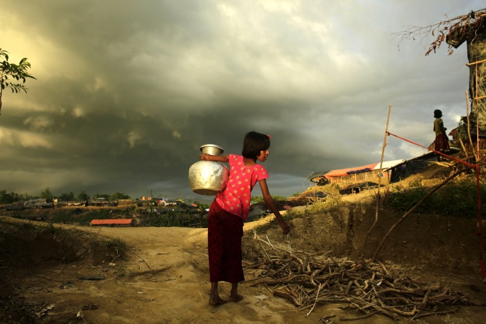 A Rohingya girl carries water to her family's makeshift tent in a camp in Cox's Bazar, Bangladesh, Oct. 5. 
