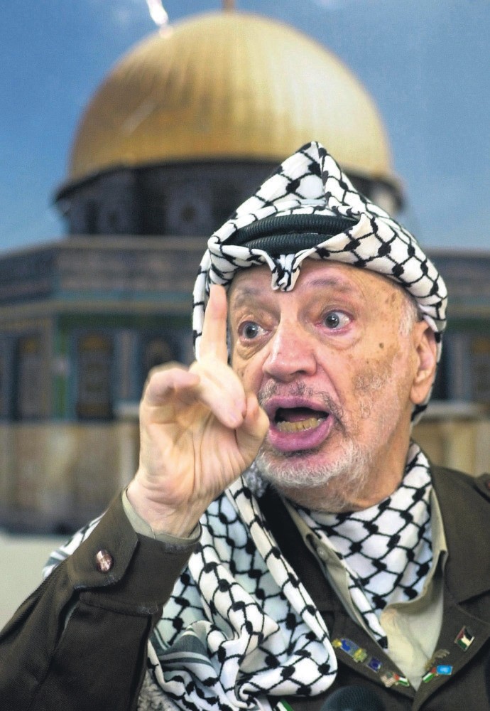 Palestinian leader Yasser Arafat talks to the media during a press conference at his headquarters, Ramallah, West Bank, 2002. 