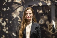 Hayal ?ncedo?an poses in front of one of her works displayed at the exhibition.