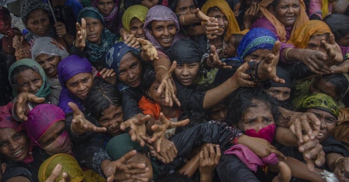 Rohingya Muslim women, who crossed over from Myanmar into Bangladesh, stretch their arms out to collect sanitary products distributed by aid agencies near Balukhali refugee camp, Bangladesh, Sunday, Sept. 17, 2017. (AP Photo)
