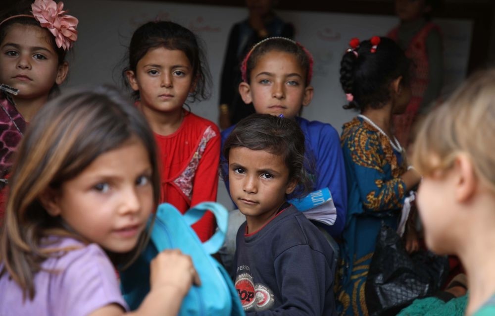 Syrian children who fled with their families from the attacks in their hometown of Hama pose in a classroom at makeshift school for displaced children, Idlib, Oct. 1. 