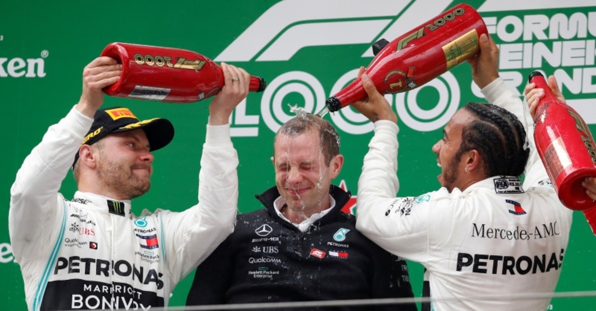 Mercedes driver Lewis Hamilton and teammate Valtteri Bottas pour champagne over team engineer Marcus Dudley during the award ceremony for the Chinese Formula One Grand Prix at the Shanghai International Circuit in Shanghai, April 14, 2019. (AP Photo)