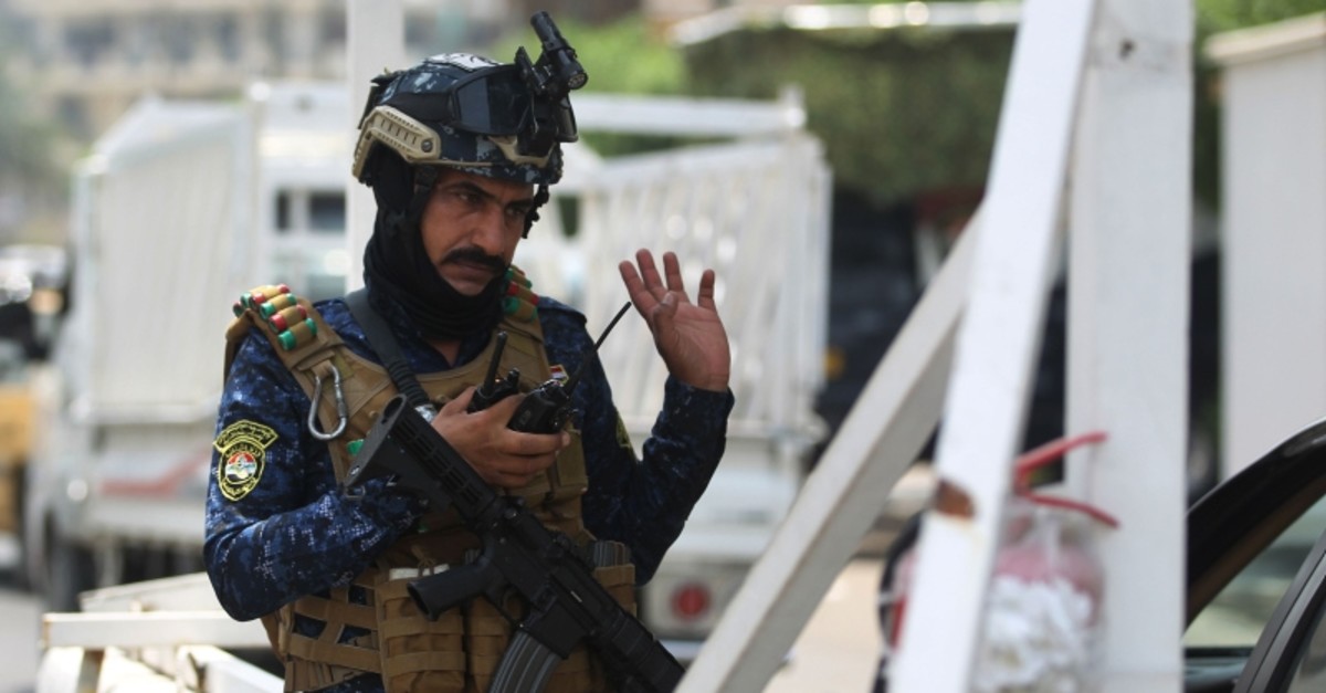 A member of the Iraqi federal police forces stands guard at a checkpoint in Baghdad's Karada district on May 20, 2019 (AFP Photo)