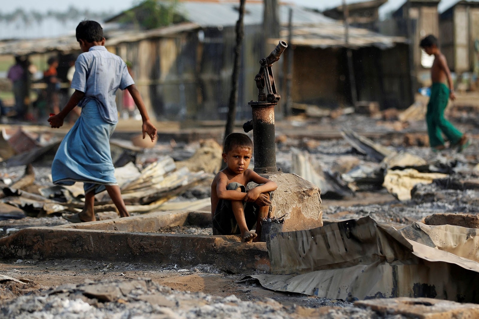 A boy sit in a burnt area after fire destroyed shelters at a camp for internally displaced Rohingya Muslims in the western Rakhine State near Sittwe, Myanmar May 3, 2016.