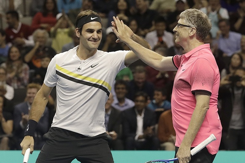 Roger Federer, of Switzerland, left, celebrates with partner Bill Gates as they play an exhibition tennis match against Jack Sock and Savannah Guthrie in San Jose, Calif., (AP Photo)