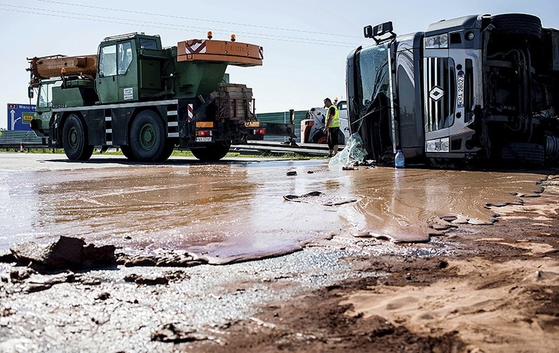 Tons of liquid milk chocolate are spilled and block six lanes on a highway after a truck transporting it overturned near Slupca, in western Poland, on Wednesday, May 9 (AP Photo)