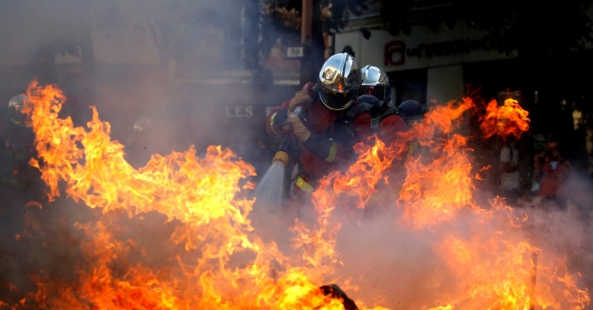 Firefighters extinguish a barricade during a protest urging authorities to take emergency measures against climate change, in Paris, France, September 21, 2019 (Reuters Photo)