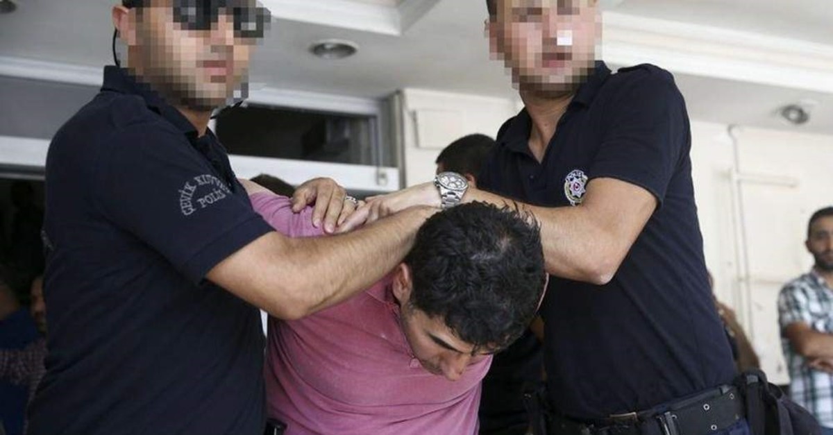 Police officers accompany Admiral Murat u015eirzai, head of Turkish naval intelligence, after he was arrested following the July 15, 2016 coup attempt. u015eirzai was sentenced to aggravated life imprisonment last year for the attempt. (AA Photo)