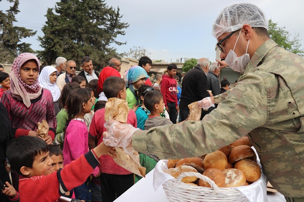 Turkish soldiers distribute bread to locals in Jinderes in Afrin from a mobile oven with the capacity to produce 6,000 loaves of bread a day, April 9. 