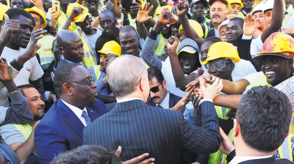 President Erdou011fan (C) shake hands with Senegalese workers as Senegal's President Macky Sall looks on, Dakar, March 1. 