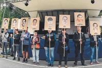 People hold portraits of NSU victims in front of the Higher Regional Court in Munich, July 10, 2018.