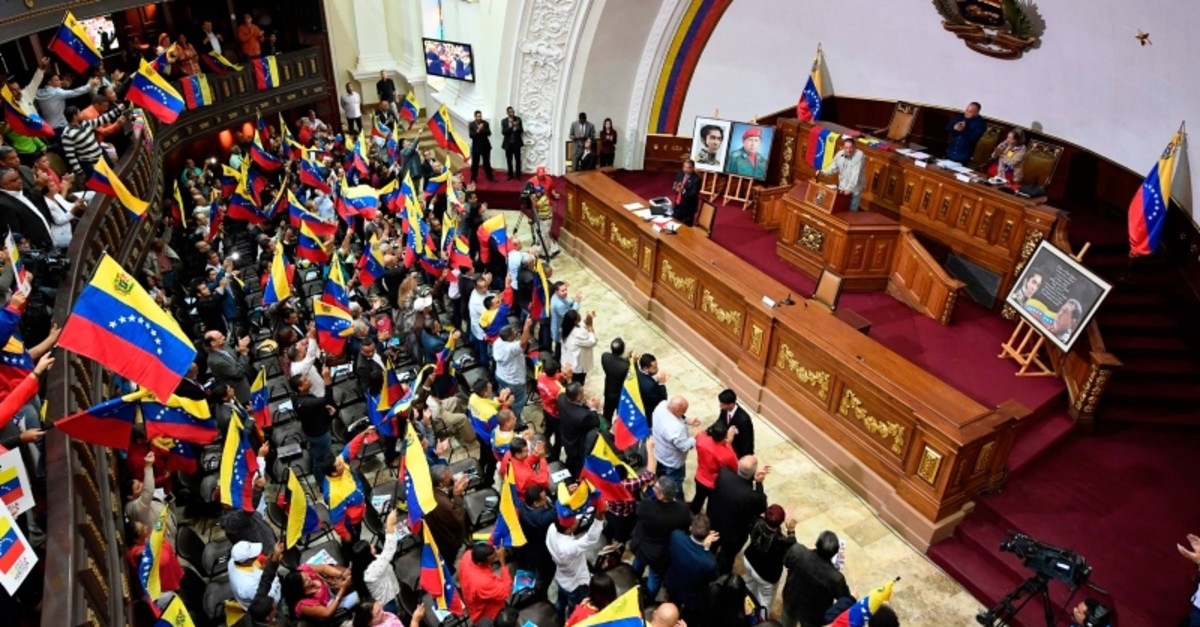 Members of the Venezuelan National Constituent Assembly (ANC) wave flags as its president Diosdado Cabello speaks, during a session at the ANC headquarters on August 12, 2019, in Caracas. (AFP Photo)