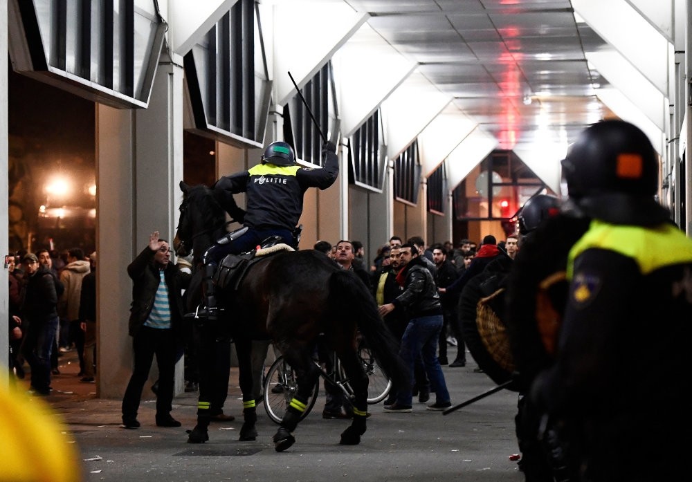 A Dutch mounted police officer raises a truncheon during protests against police treatment of a minister,preventing her from addressing people in front of Turkish Consulate in Rotterdam,which led to a diplomatic crisis between Turkey & Netherlands.