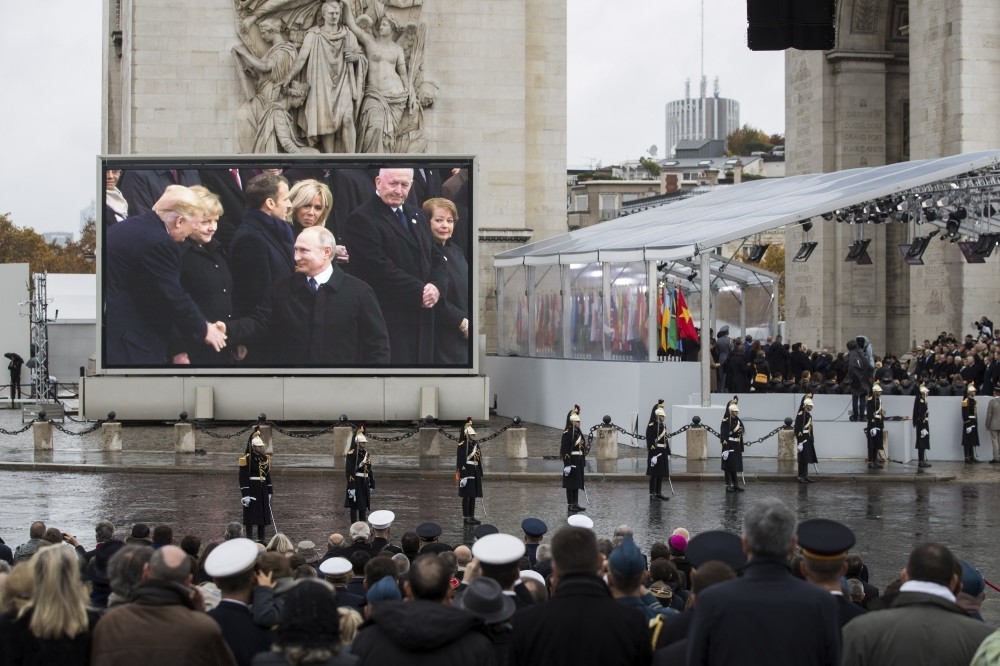 U.S. President Donald Trump (L) and Russian President Vladimir Putin (C) shown on a screen shaking hands during a ceremony for the Centenary of the World War I Armistice of Nov. 11, 1918, at the Arc de Triomphe, in Paris, France, Nov. 11.