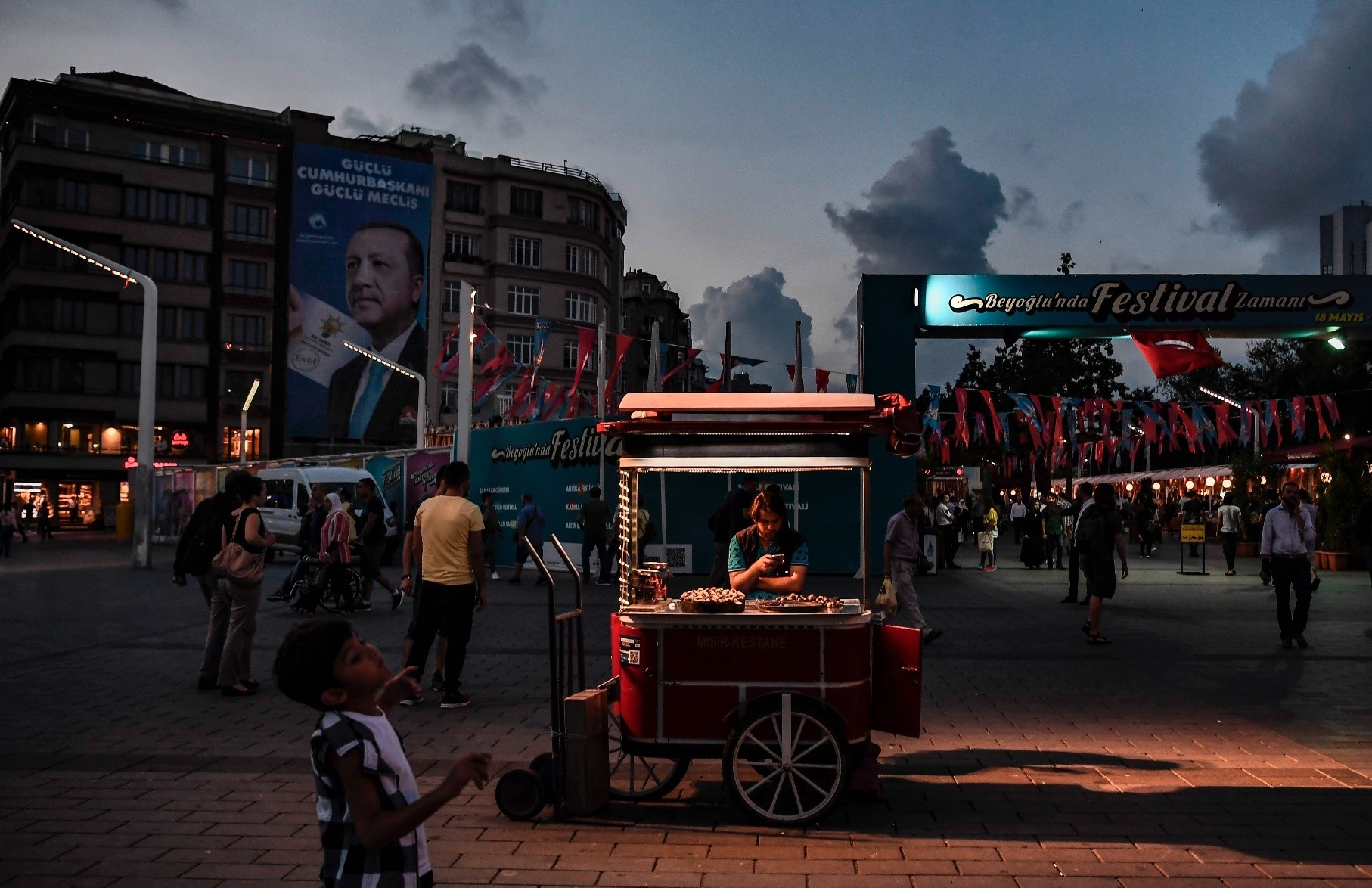 A man sells chestnuts in Taksim square under a campaign poster of President Erdou011fan, Istanbul, July 18.