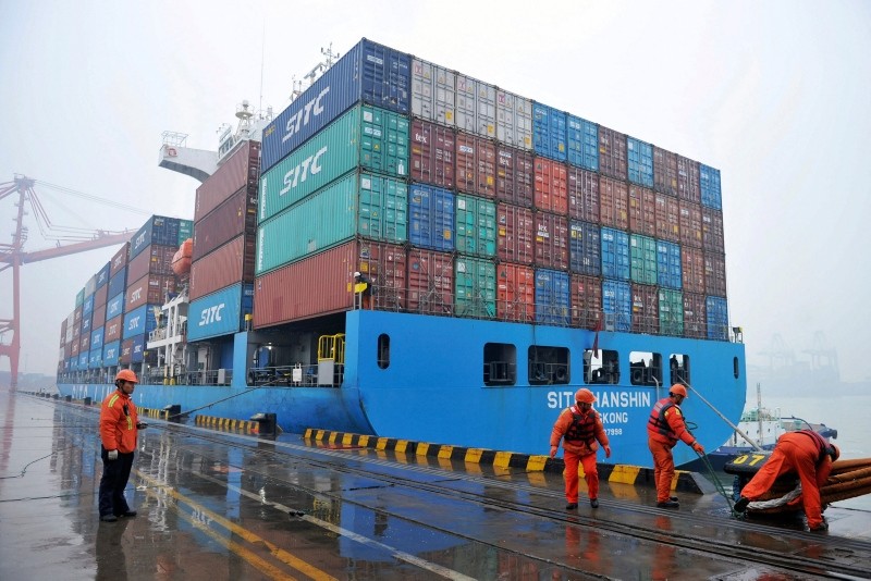 In this Friday, Jan. 11, 2019, photo, workers moor a container ship at a port in Qingdao in east China's Shandong province (Chinatopix via AP)