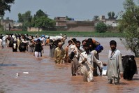In a file picture taken on July 31, 2010, evacuating residents carry their belongings through floodwaters in the Mohib Bhanda area in Nowshera district. (AFP Photo)