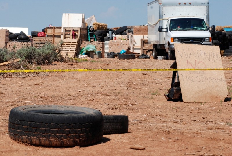Police tape restricts access to a disheveled living compound in Amalia, N.M., on Tuesday, Aug. 7, 2018. (AP Photo)