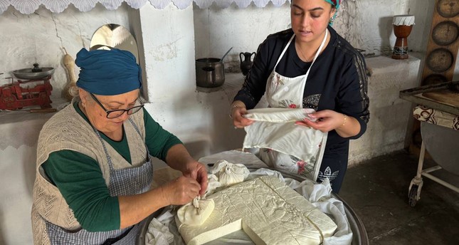 مطبخ عائلة سربيل قاضي كوي والبالغ عمره 65 عاماً في قرية أكدنيز بقبرص التركية يجذب السياح لإنتاج جبنة حلوم على طريقة الأجداد صورة: الأناضول