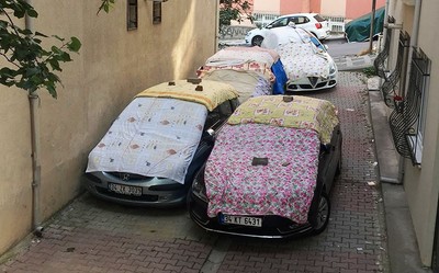 Residents prepare for the storm by covering their cars with blankets.