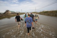 People walk through streets flooded from Hurricane Nate on Dauphin Island, Alabama.