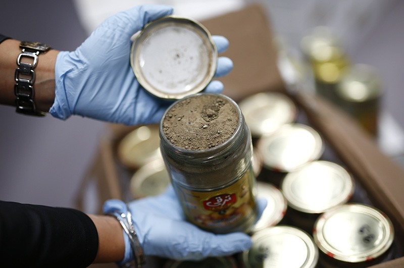A member of the German Criminal Investigation Division (BKA) displays a glass jar of seized heroin in Wiesbaden (Reuters File Photo)