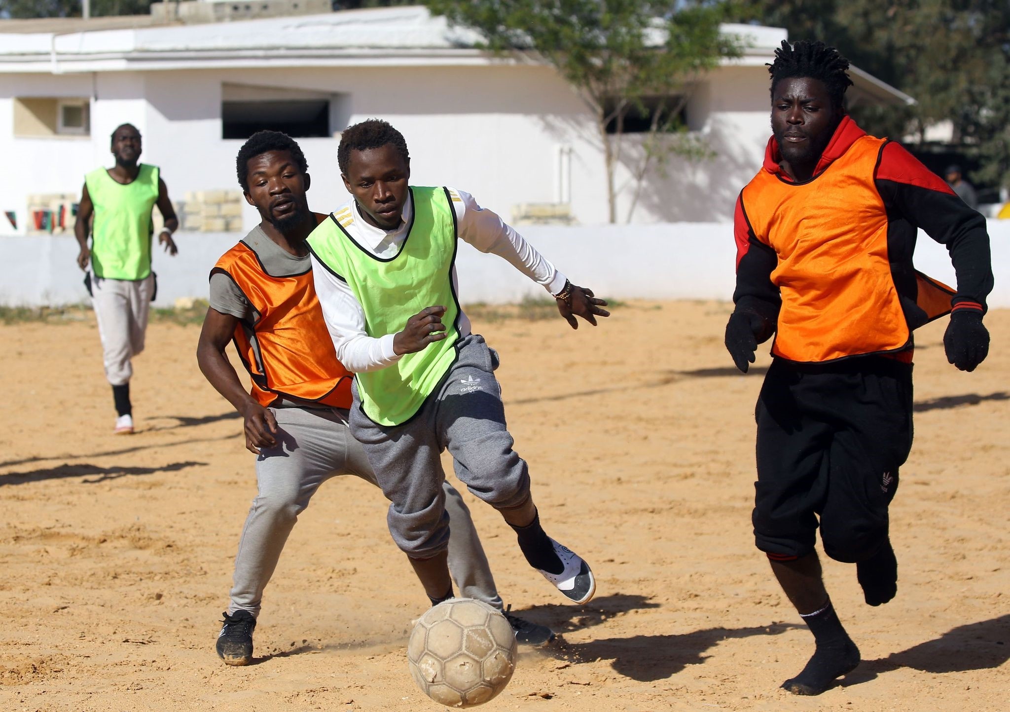 Cameroonian (orange) and Senegalese (yellow) African migrants, split into two teams for a football match at the Libyan Interior Ministryu2019s illegal migration shelter in Tajoura.