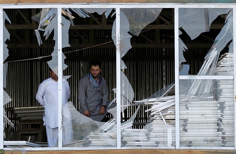 Afghan men look outside a broken window at the site of a suicide attack in Kabul, Afghanistan Sept. 9, 2018. (Reuters Photo)