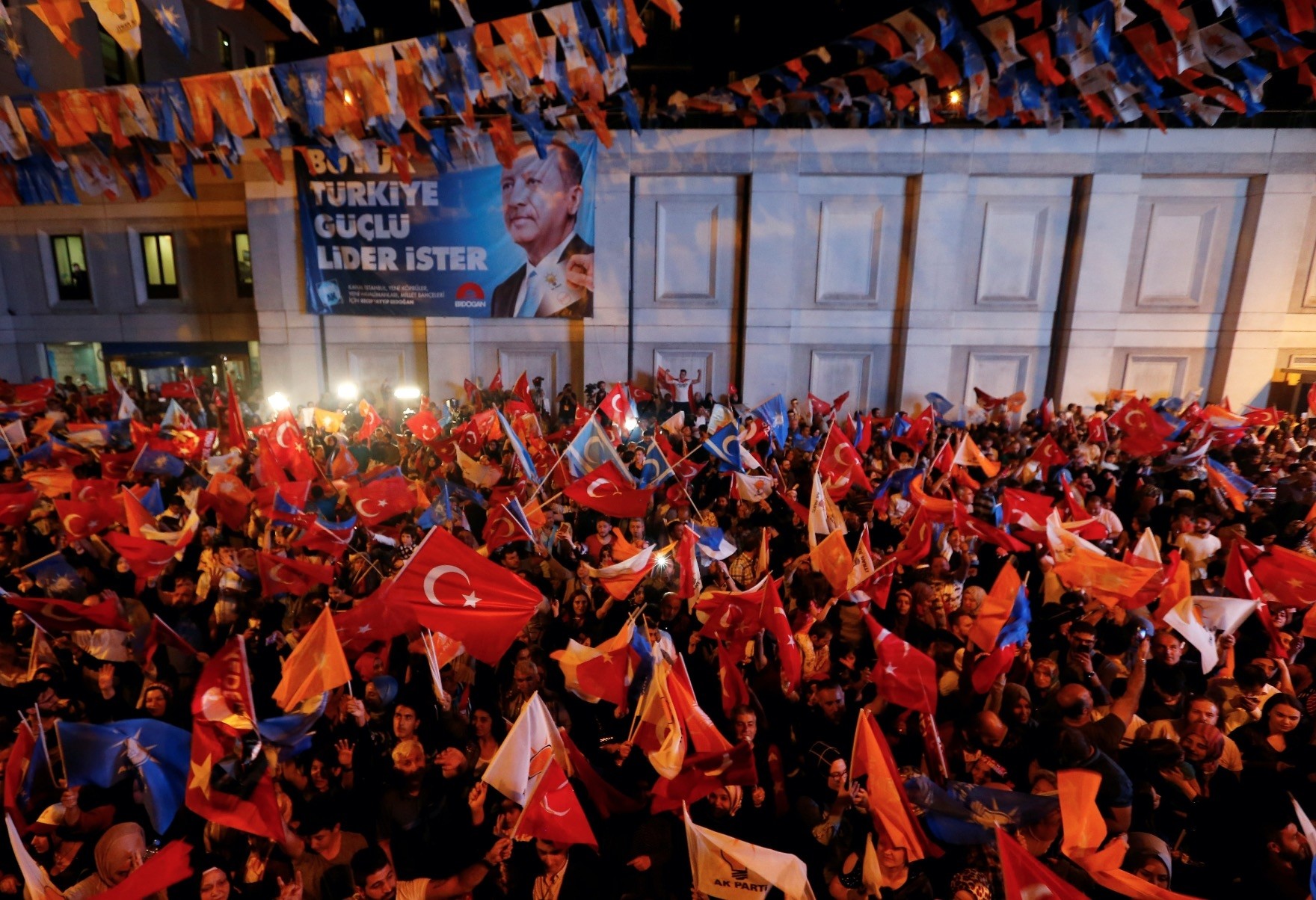People waving flags to celebrate President Erdou011fan's victory in presidential and parliamentary elections, outside his AK Party's headquarters, Istanbul, Sunday.