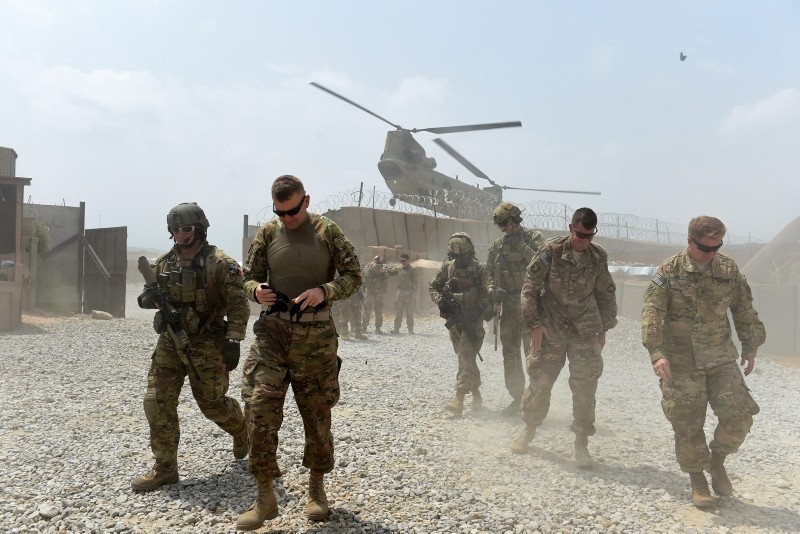 This Aug. 13, 2015 shows U.S. army soldiers walk as a NATO helicopter flies overhead at coalition force Forward Operating Base (FOB) Connelly in the Khogyani district in the eastern province of Nangarhar, Afghanistan. (AFP Photo)
