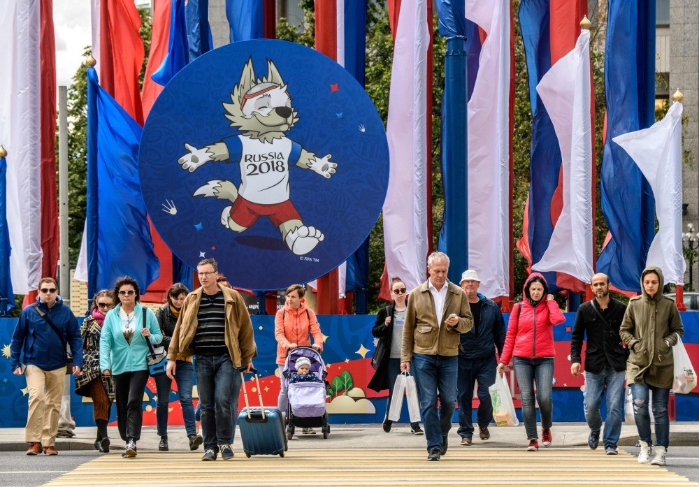 People walk in front of a 2018 FIFA World Cup decoration featuring the tournament mascot ,Zabivaka,, Moscow, June 7.