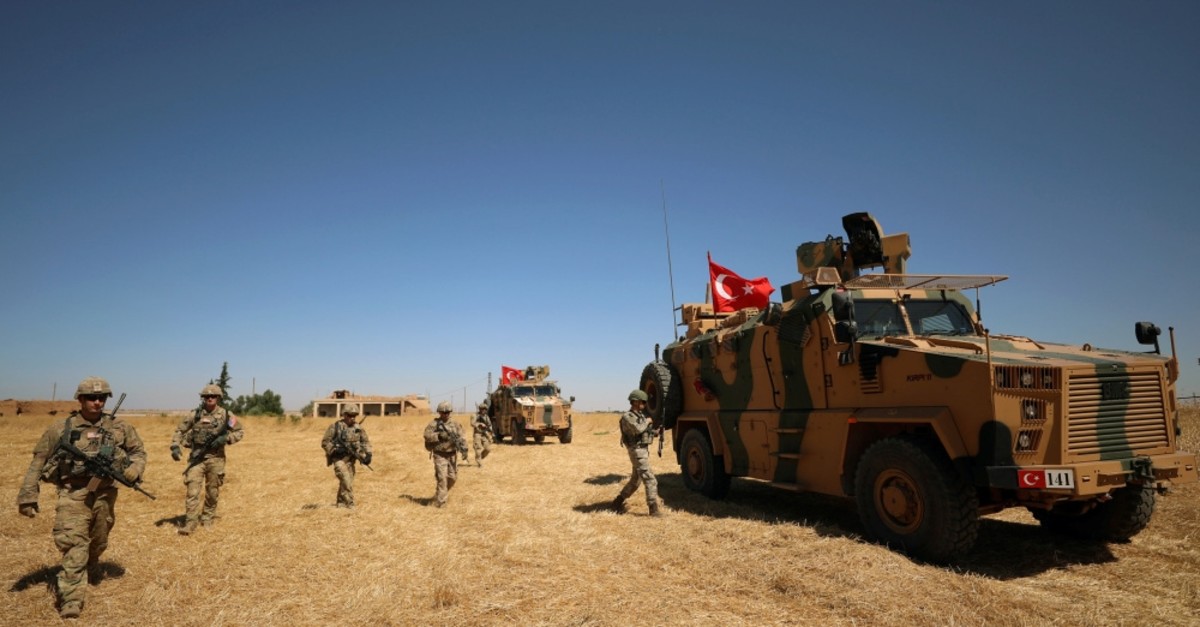 U.S. soldiers stand guard during a joint patrol with Turkish troops in the Syrian village of al-Hashisha, on the outskirts of Tal Abyad, along the border with Turkey, Sept. 8, 2019. 