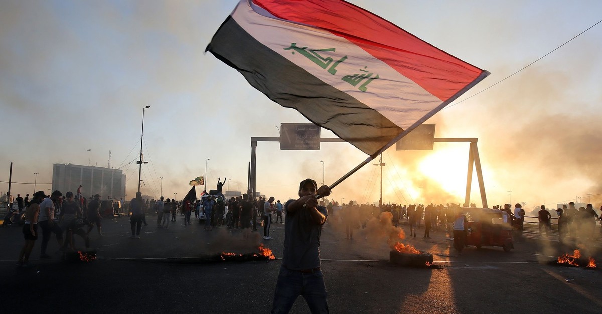 An Iraqi protester waves the national flag during anti-government demonstrations, Baghdad, Oct. 5, 2019.