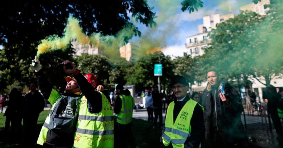 Protestors hold up a flare as they take part in a demonstration called by the Yellow vest (Gilets jaunes) movement on May 4, 2019 in Paris (AFP Photo)