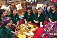 Women in traditional cloths enjoy the meals they have prepared using their grandmothers' recipes.
