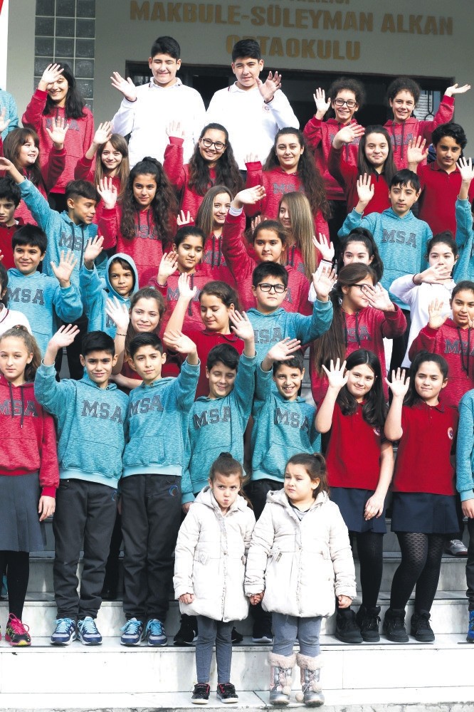 Twins and triplets pose in front of their school.
