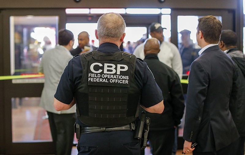 A Customs and Border Protection (CBP) federal officer watches from inside the terminal during a protest at Hartsfield-Jackson Atlanta International Airport (EPA Photo)