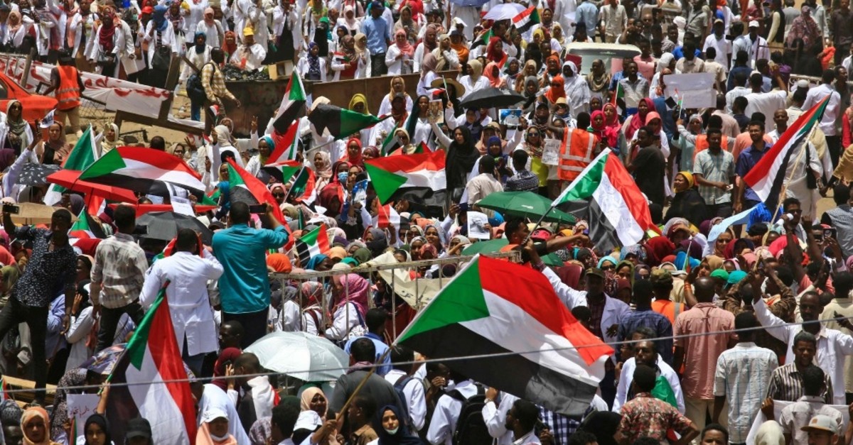 Sudanese protesters wave signs and flags as they continue to protest outside the army complex, Khartoum, April 17, 2019.