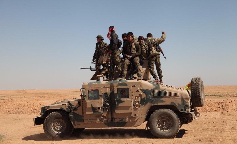 YPG-dominated SDF fighters are seen on the top of a U.S. armored vehicle in the Raqqa operation.