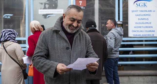 مواطن يبتسم أثناء النظر في الأوراق التي تسمح له بالتقاعد وفقًا للائحة الجديدة ، أنقرة ، تركيا ، 29 ديسمبر ، 2022 الأناضول