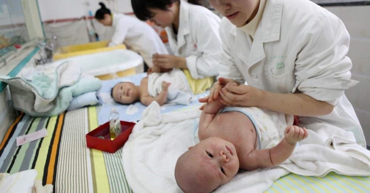 Nurses massage babies at an infant care center, Yongquan, Dec. 15, 2016. (AFP Photo)