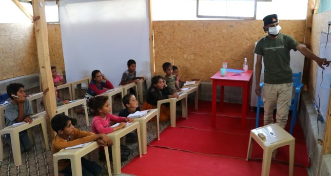 أحمد محيميد مع تلاميذه في مدرستهم الصغيرة IHA
