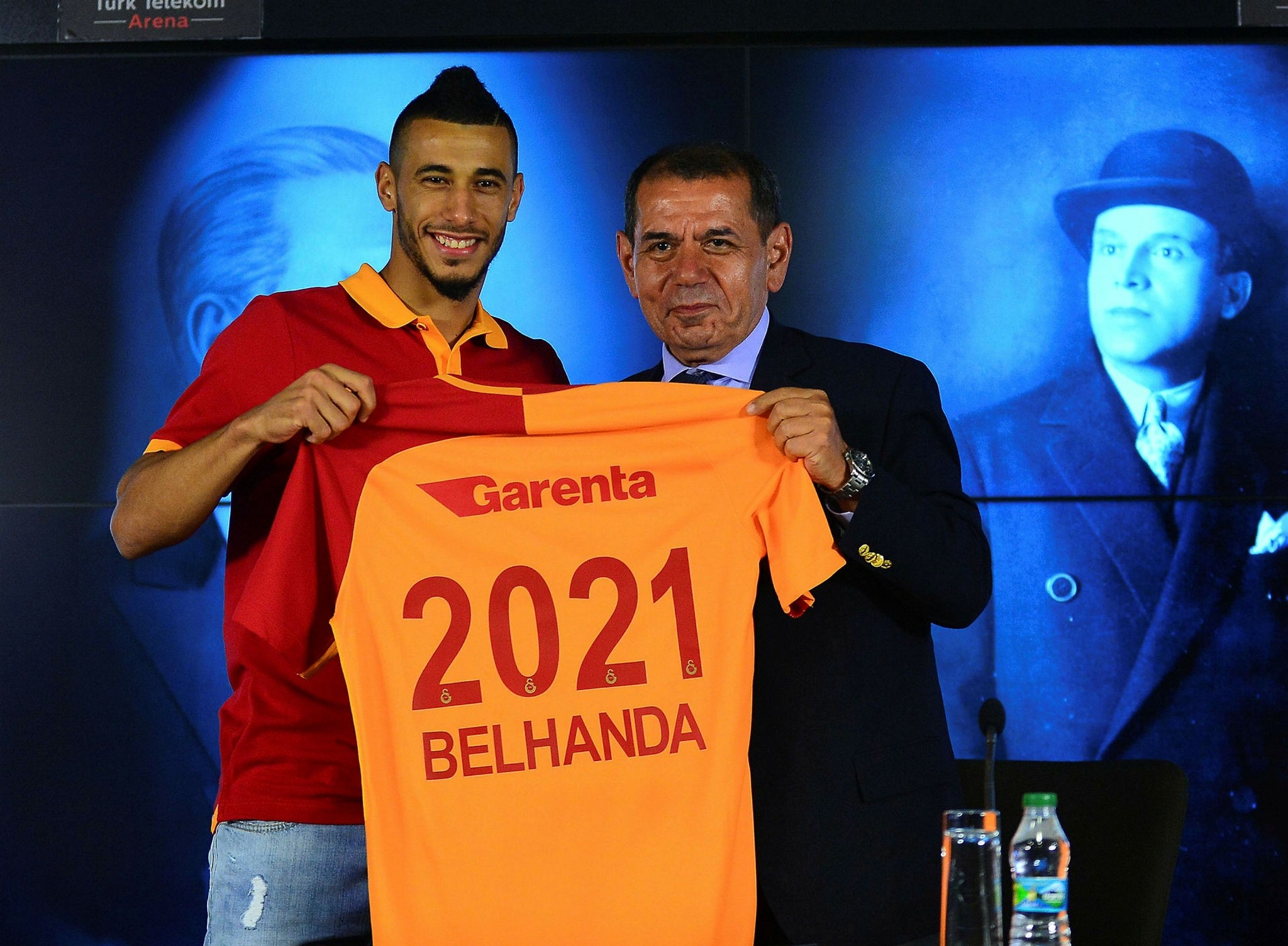 Younes Belhanda holds up a Galatasaray jersey in a ceremony with Chairman Dursun u00d6zbek.