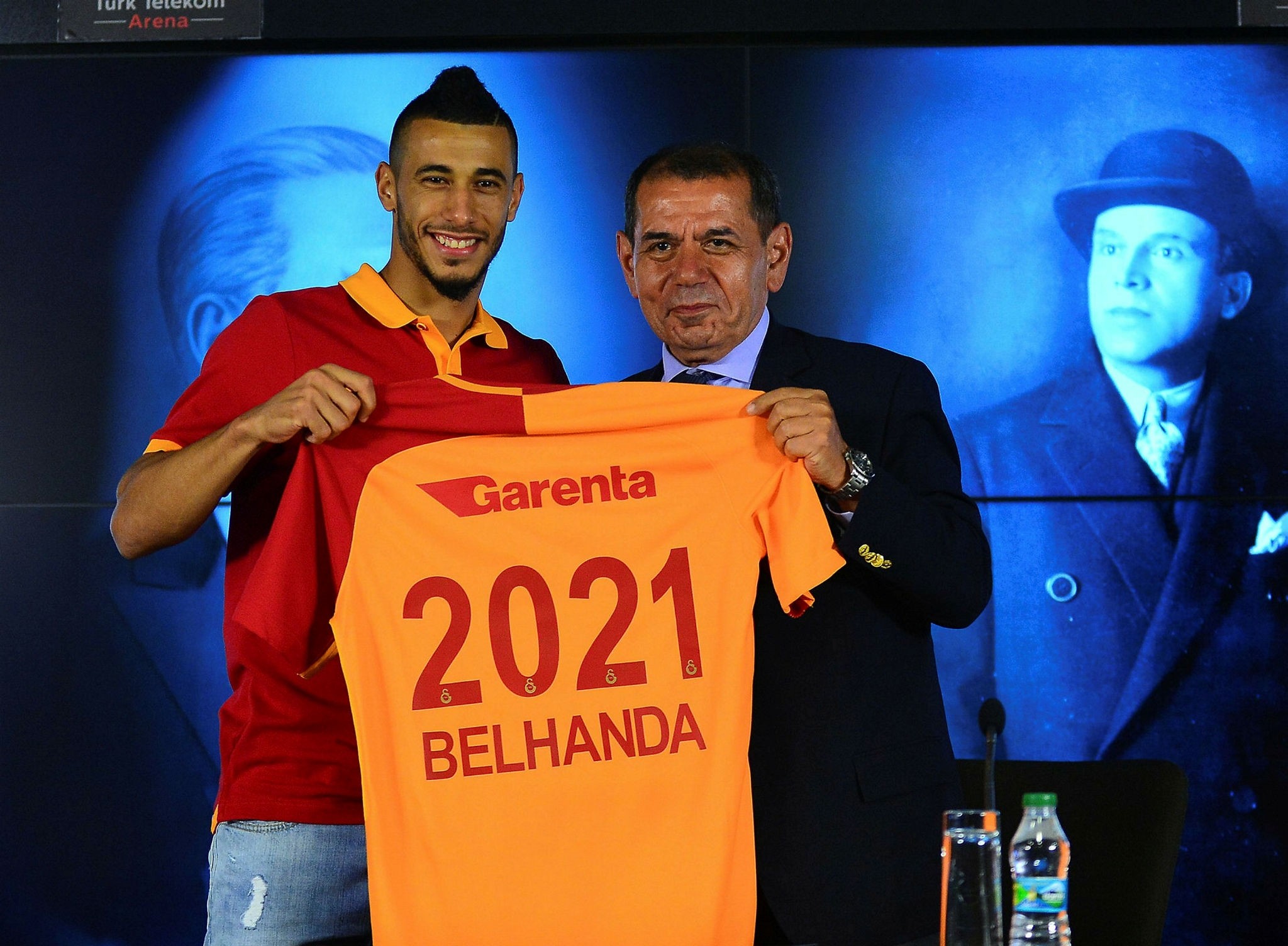 Younes Belhanda holds up a Galatasaray jersey in a ceremony with Chairman Dursun u00d6zbek.