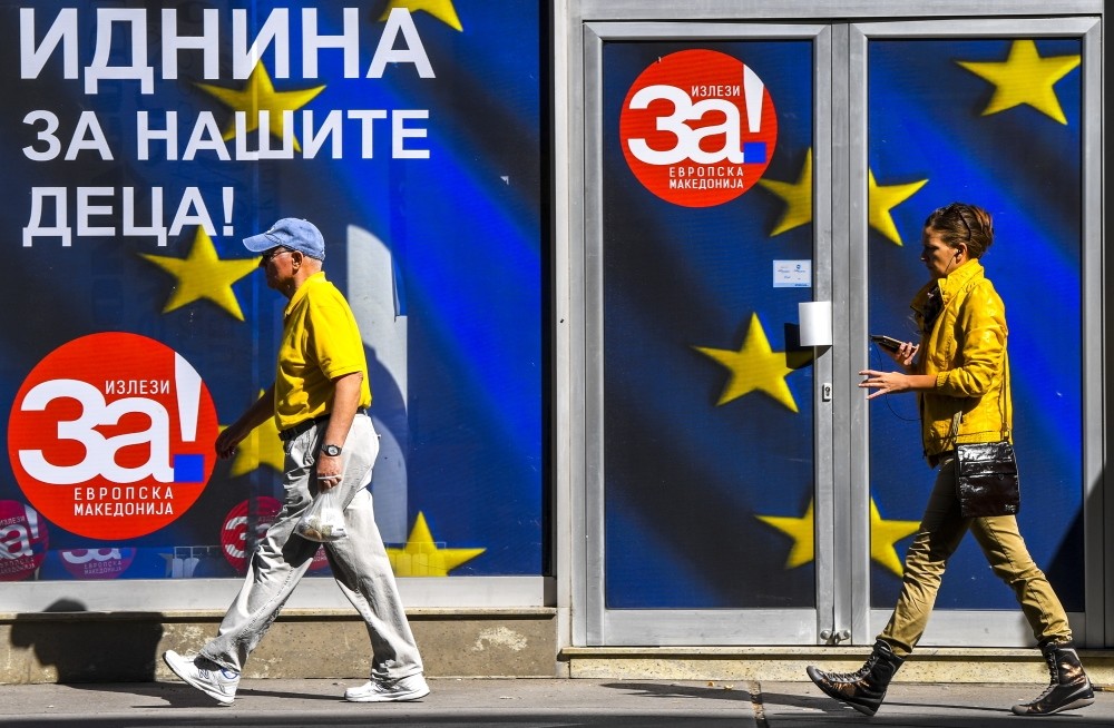 Macedonians pass an office of the coalition that supports the upcoming referendum, Skopje, Sept. 28.