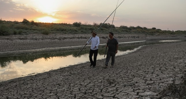 سوريان يسيران جنب نهر الخابور في شمال شرق سوريا رويترز