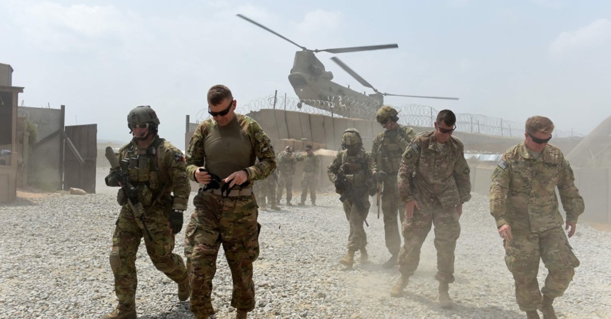 U.S. soldiers walk as a NATO helicopter flies overhead  at coalition force Forward Operating Base (FOB) Connelly in the Khogyani district in the eastern province of Nangarhar, Afghanistan, Aug. 12, 2015. 