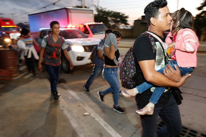 U.S.-bound migrants walk along the roadside as they leave San Pedro Sula, Honduras, at dawn Tuesday, Jan. 15, 2019 (AP Photo)