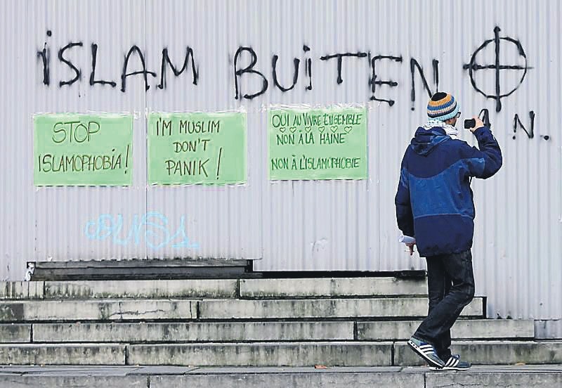 Pasted signs reading ,stop islamophobia, and ,I'm muslim don't panic, are seen under anti-Islam grafitti during a protest against Islamophobia in front of the Brussels' Justice Palace on Oct. 26.